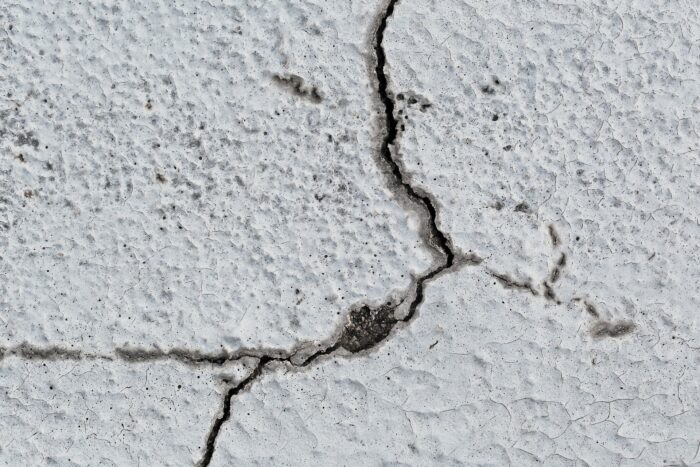 外壁に生じた幅の広いひび割れと劣化の進行が見られる状態