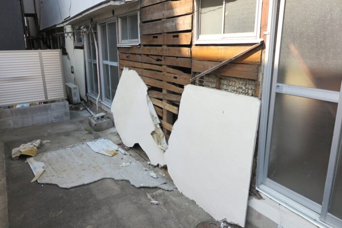 外壁の一部が大きく剥がれ下地が露出した建物