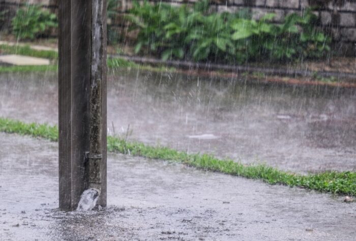 大雨で縦樋から流れ出る雨水