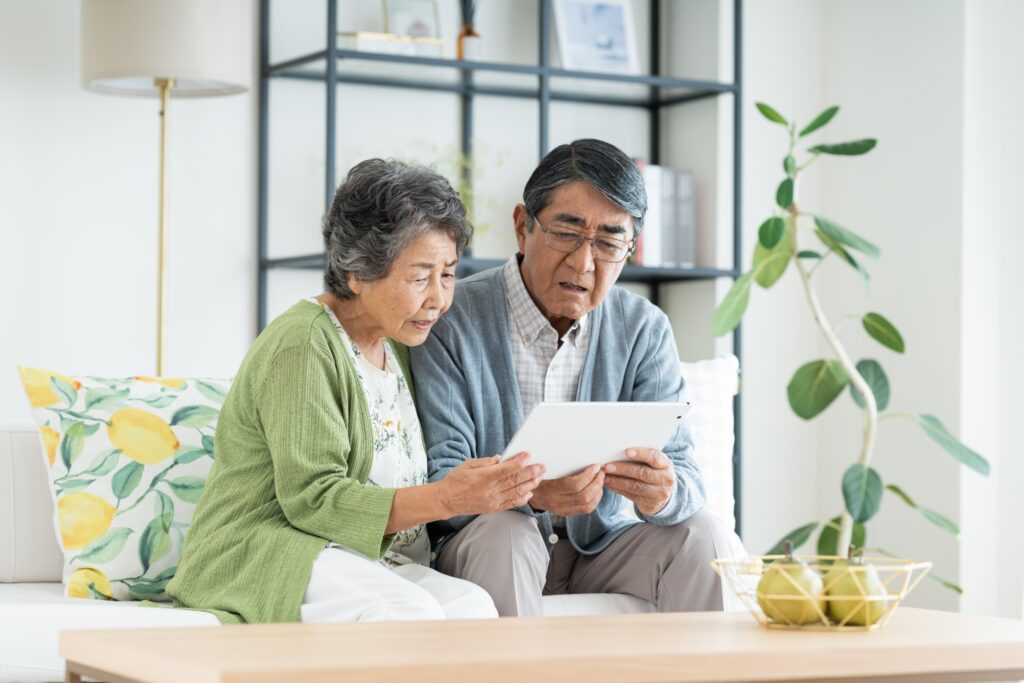 管理会社からの報告を確認する高齢オーナー夫婦のイメージ