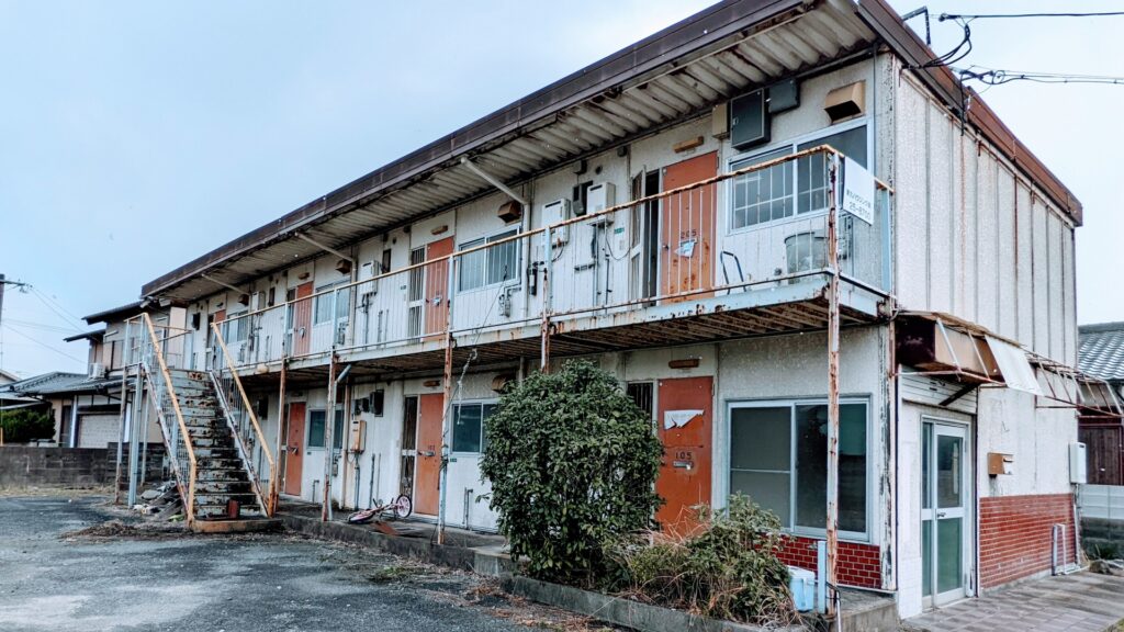 外壁の劣化・錆びた手すりが目立つ老朽化したアパートの外観