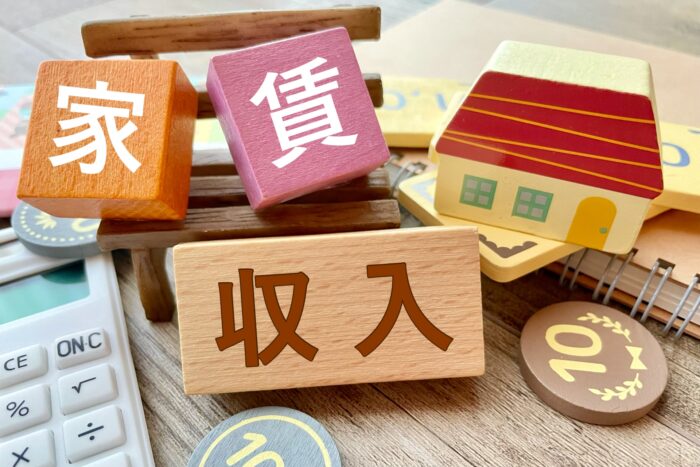 家賃収入をイメージした家の模型と「家賃」の文字