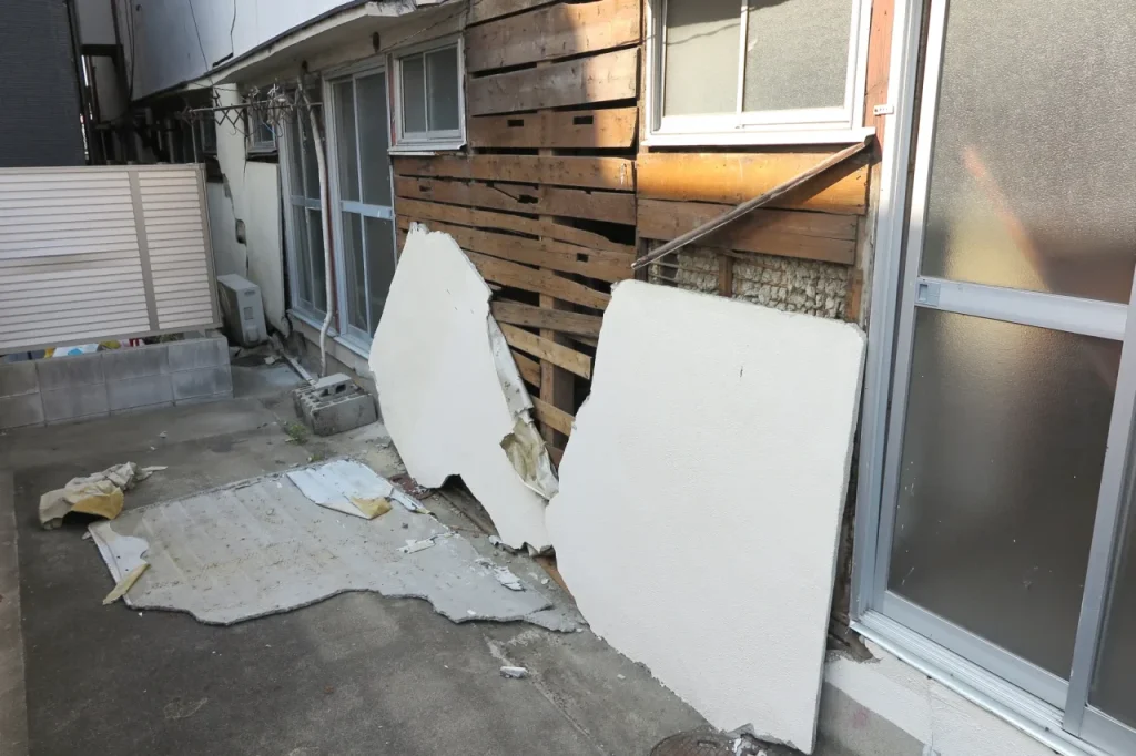 外壁の一部が大きく剥がれ下地が露出した建物