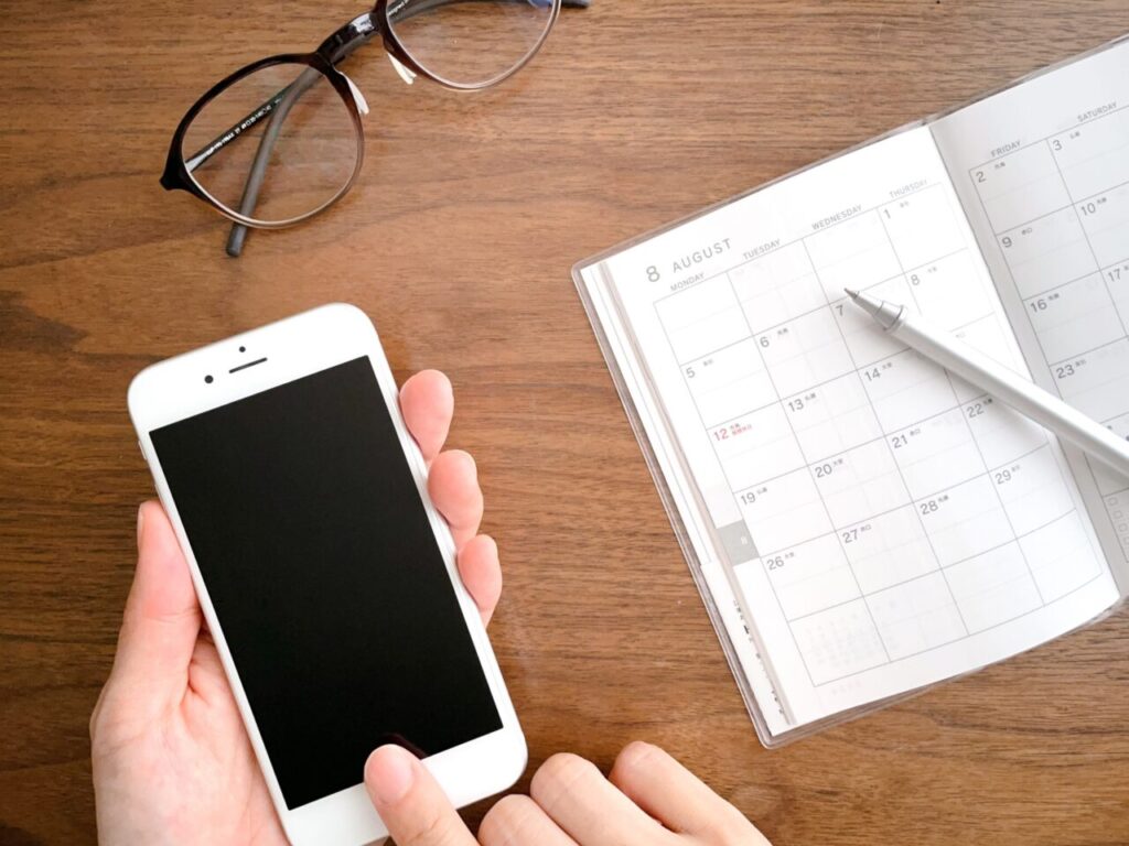 スマートフォンと手帳を確認する様子
