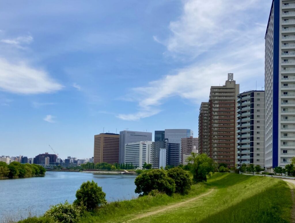 河川沿いに建ち並ぶ高層マンションと周辺の街並み